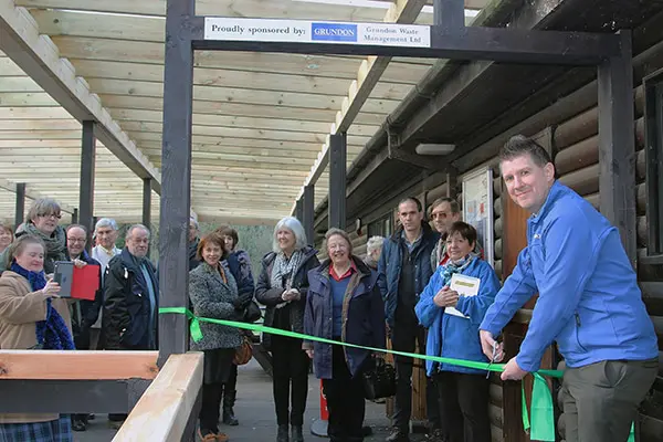 Officially open for business: Anthony Foxlee-Brown cutting the ribbon to open the veranda cheered on by Colne Valley Park Volunteers, local Councillors and representatives from Bucks Country Parks