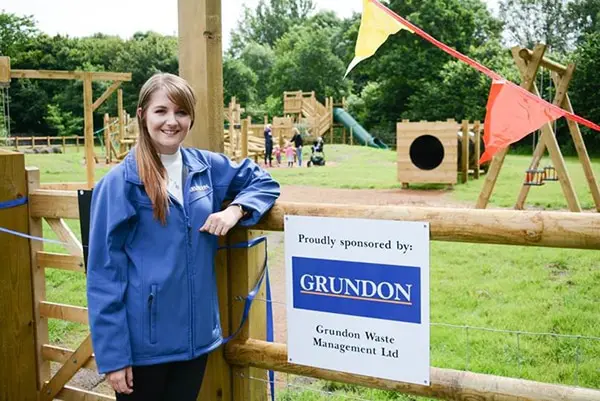Kirsti Santer, Marketing Assistant, at Grundon Waste Management stands proudly at the entrance to the new play area at Denham Country Park