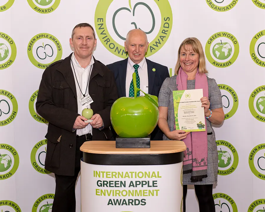 Paul Whitehill, Assistant Hotel Services Manager at the Frimley Health NHS Foundation Trust (left) and Becky Lillywhite, Contract Manager – Clinical at Grundon Waste Management (right), collect the Silver Green Apple Award for Environmental Best Practice in the Wastes Management NHS and Healthcare category from Roger Wolens, Founder of The Green Apple Awards and Chief Executive Officer of The Green Organisation (centre)