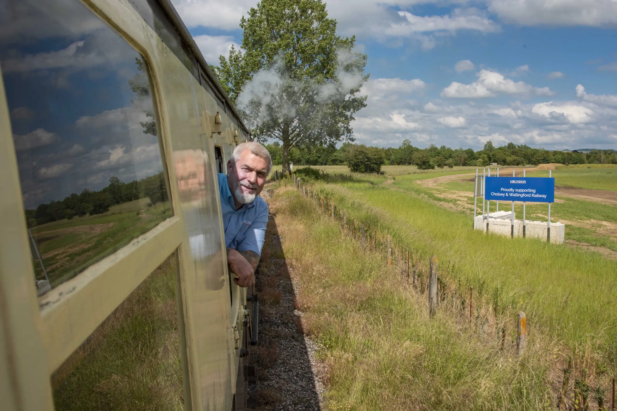 Peter Kent enjoys the view as the train steams post Grundon’s New Barn Farm quarry, near Cholsey.