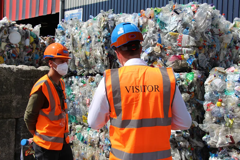 Sebastian Vettel (left) listens intently as Owen George explains the process of baling plastic bottles from Grundon’s Materials Recovery Facility before they are sent for reprocessing.